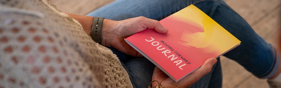 Woman reading a booklet entitled Moving Forward