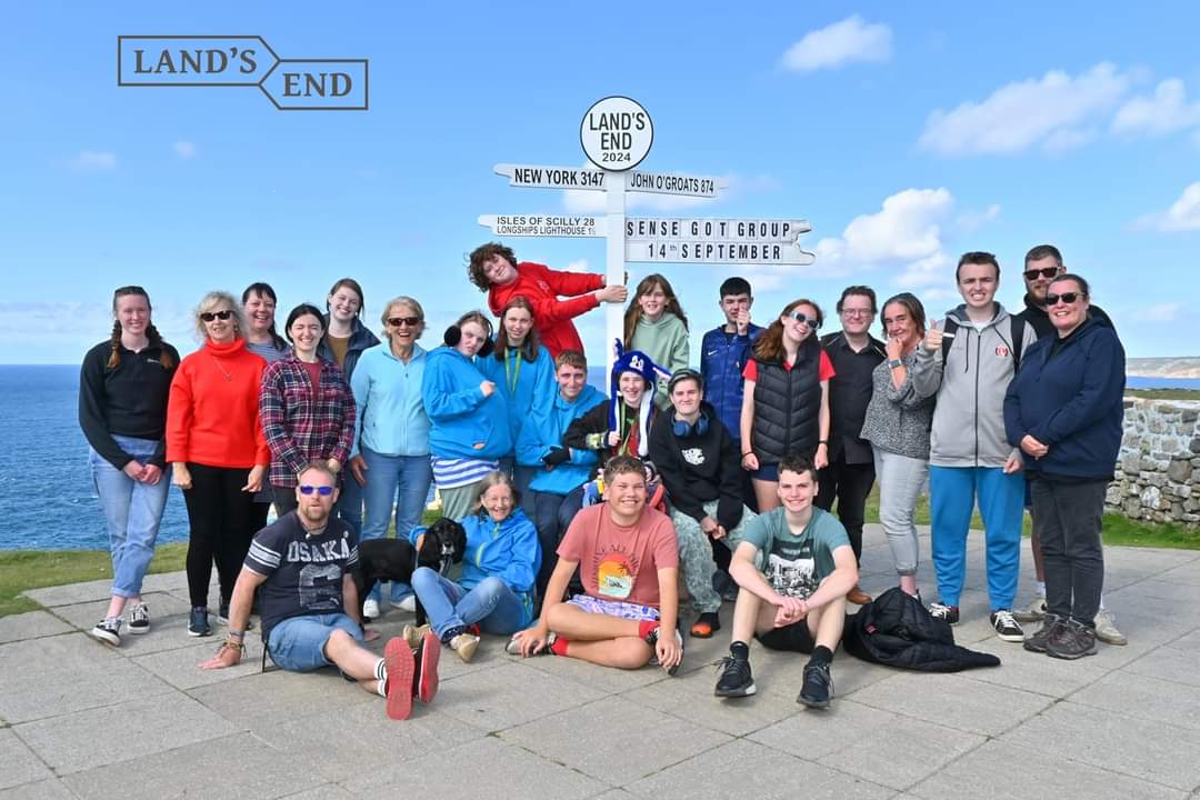 Picture of our young people at land's end. They are all standing next to the land's end sign and smiling.