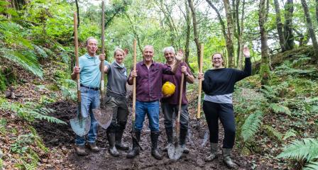 A group of volunteers with shovels at Treffry Viaduct, having cleared mud from the footpath. 