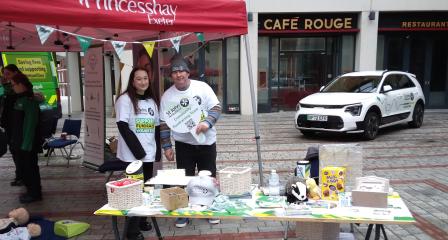 photo of a community fundraising stand with two volunteers