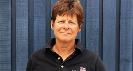 Image of Lifeboat Volunteer Manager, smiling in front of a lifeboat station. 