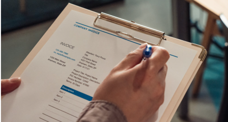 Close up of a hand Marking a clipboard with a pen